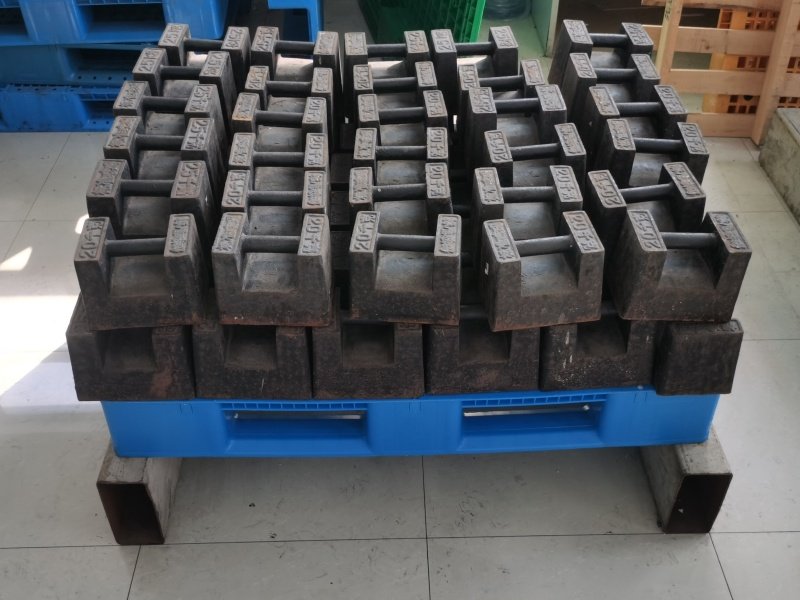 Load-bearing test for 6 runners plastic pallet, showing static weight pressure applied by calibrated iron blocks to verify pallet's structural strength and deformation resistance under heavy-duty conditions.