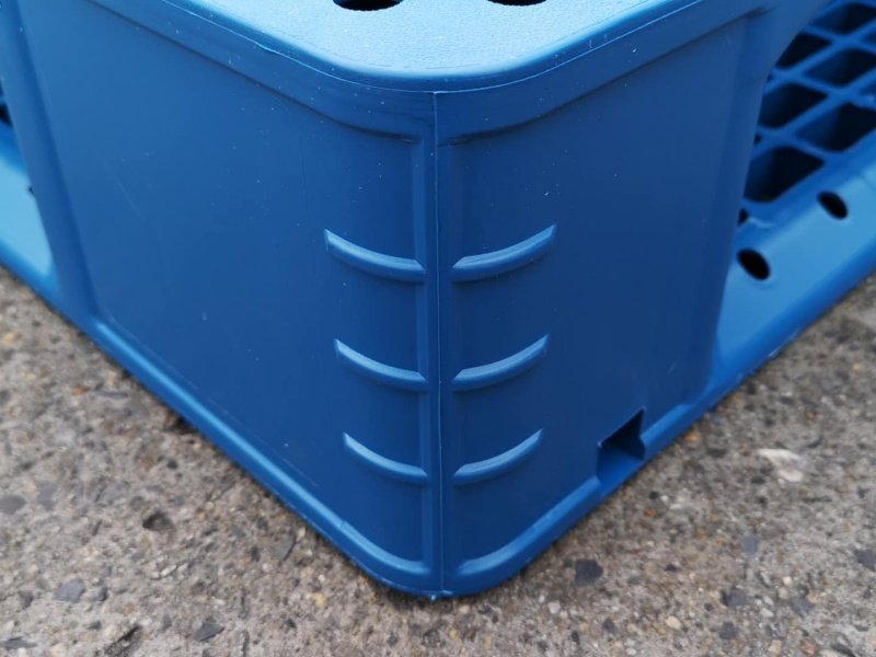 Corner structure of 6 runners pallet with molded rib reinforcements, enhancing impact resistance during forklift contact.