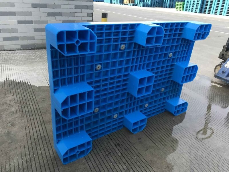 The blue nine leg plastic pallet is prevented from being placed on the factory floor, and the mesh surface is provided with multiple anti-skid pads, showing the flexibility of customization